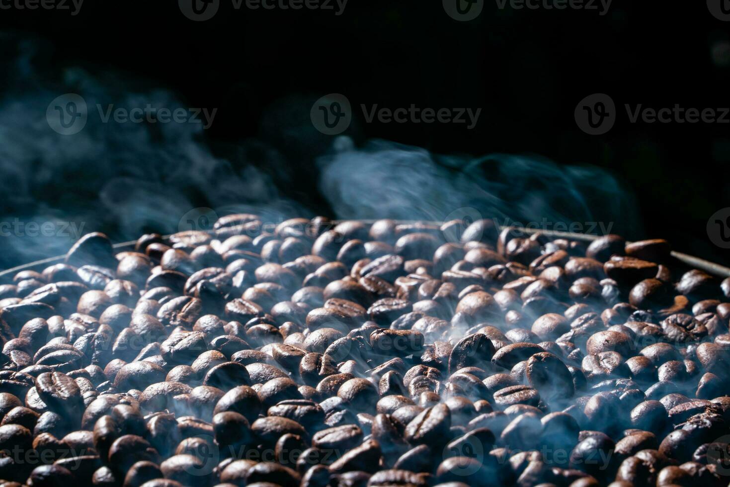 Coffee beans roasting with smoke,  selective focus, and soft focus. photo