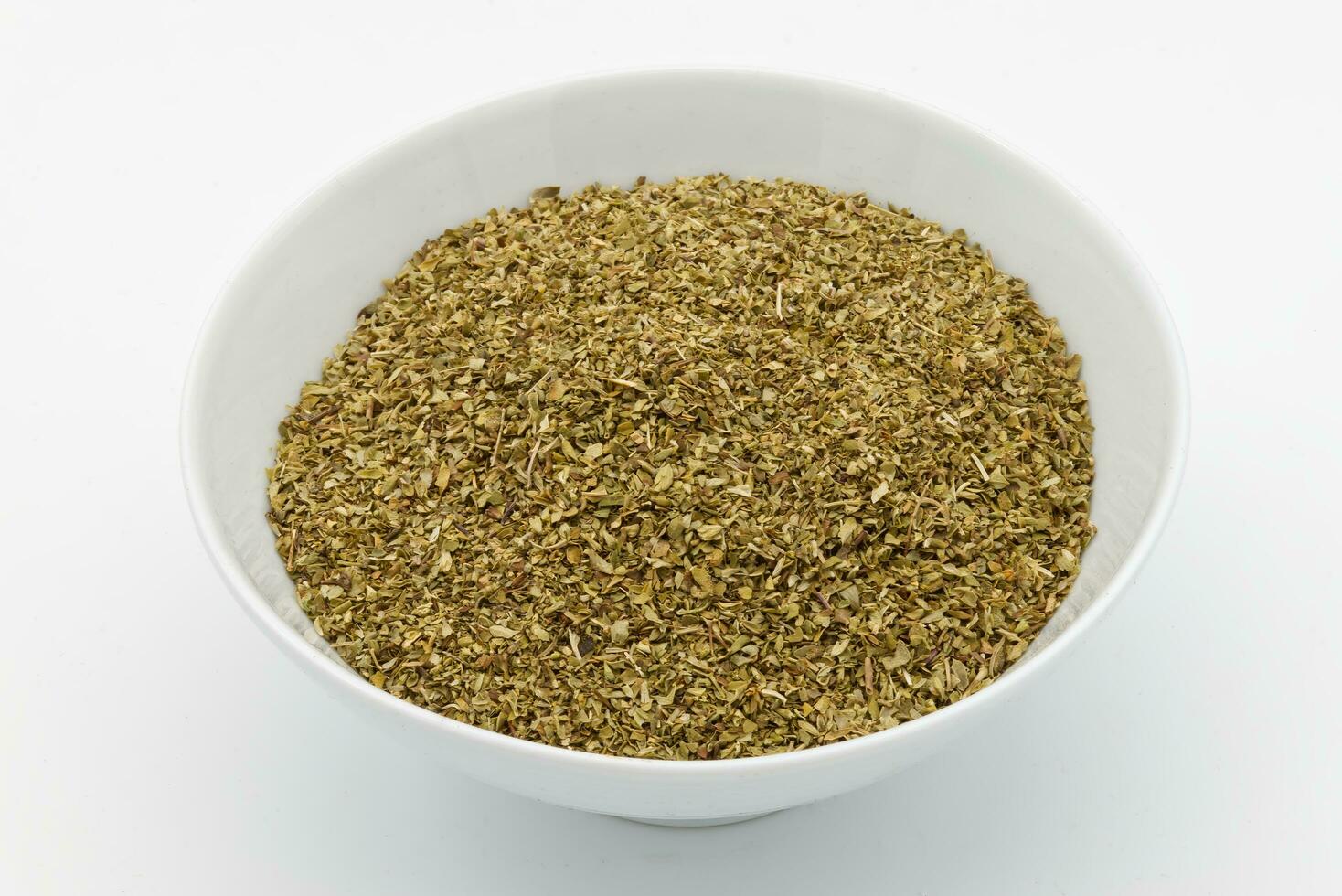 A bowl of dried oregano isolated on white background. photo