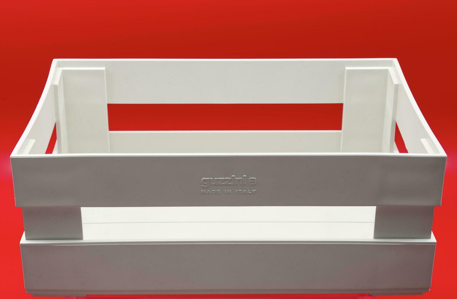Bologna  Italy  May 23, 2023 A white kitchen utensils holder isolated on red background. Design object made in Italy by Guizzini with recycled material. photo