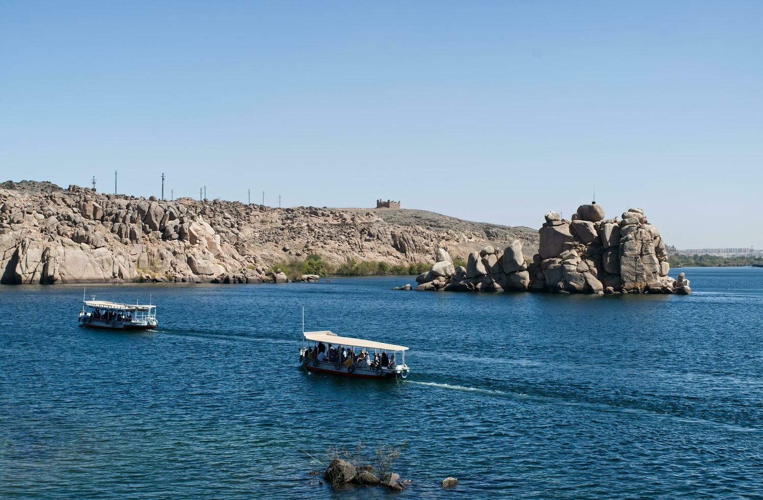 Aswan, Egypt, April 20, 2023 Boats approaching the temple of Philae, complex dedicated to the goddess Isis. Egypt. photo