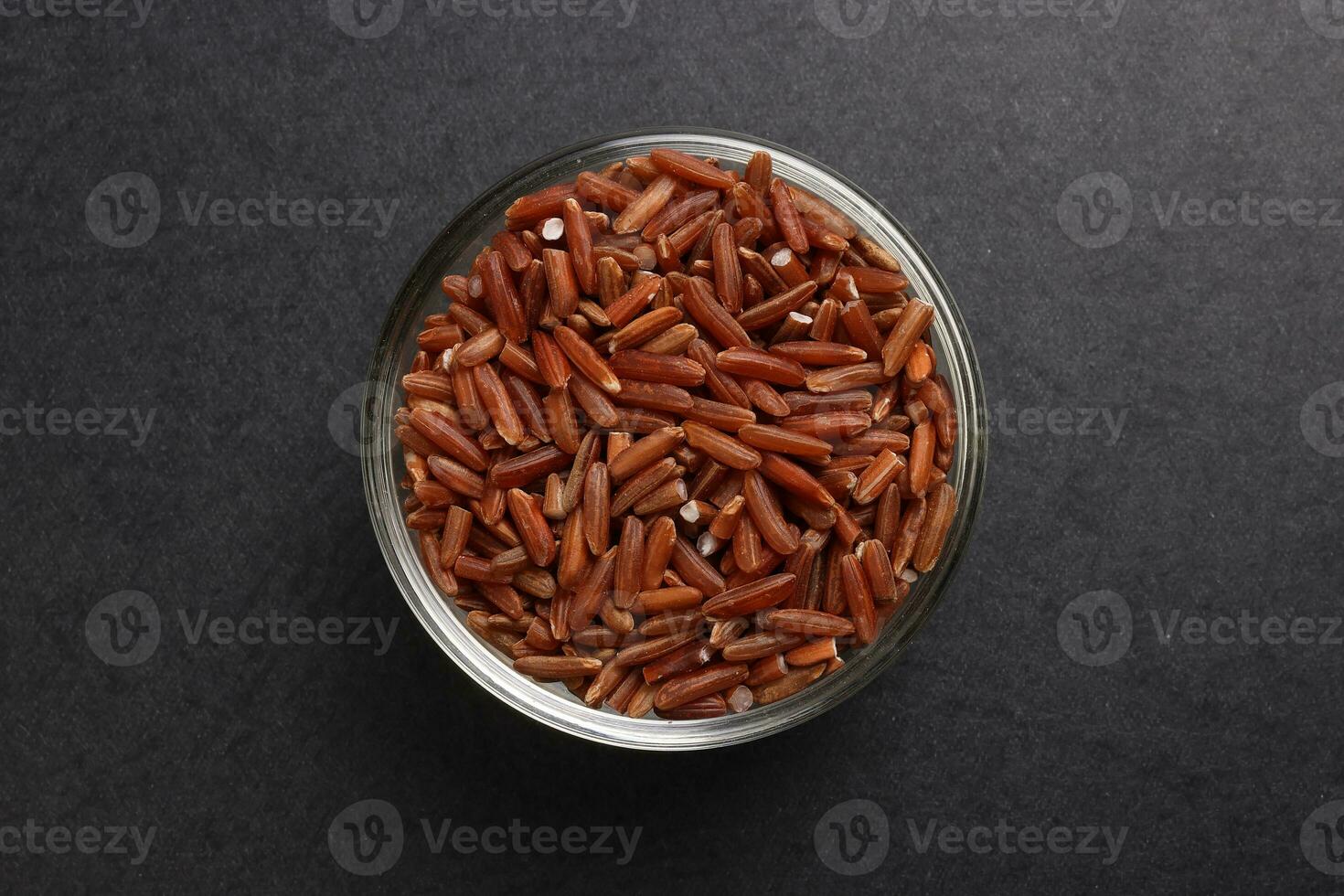 Brown low glycaemic index gi rice in glass bowl on black background photo