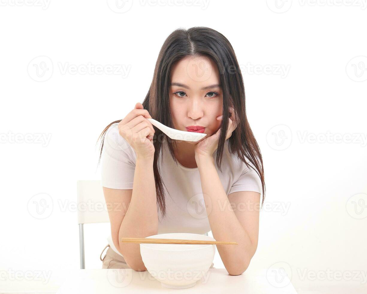 Beautiful young south east Asian woman holding chinese empty chopstick soup spoon bowl utensil pretend acting posing see eat taste feed offer satisfaction yummy white background happy photo