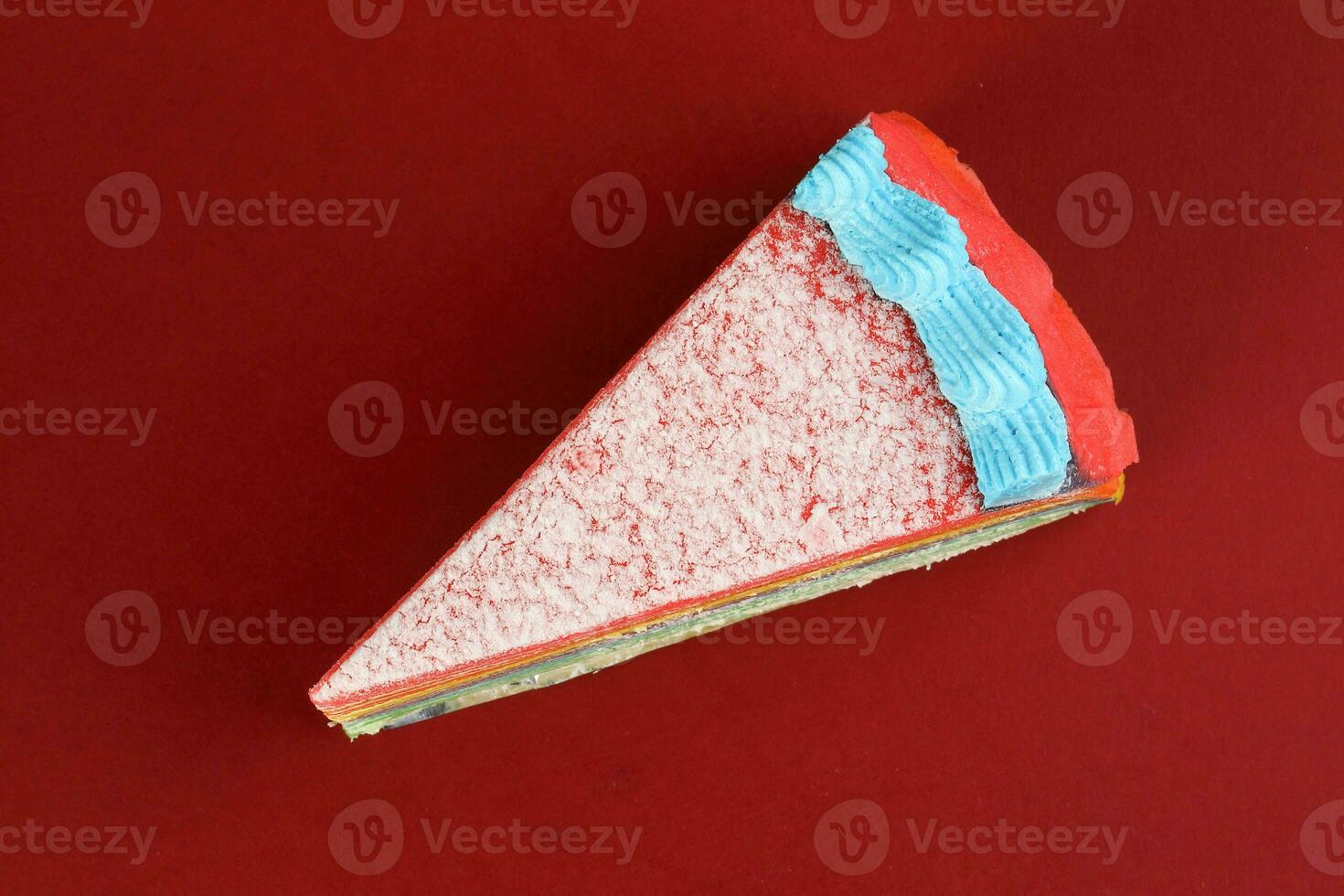 Rainbow crepe layer cake top view on red background photo