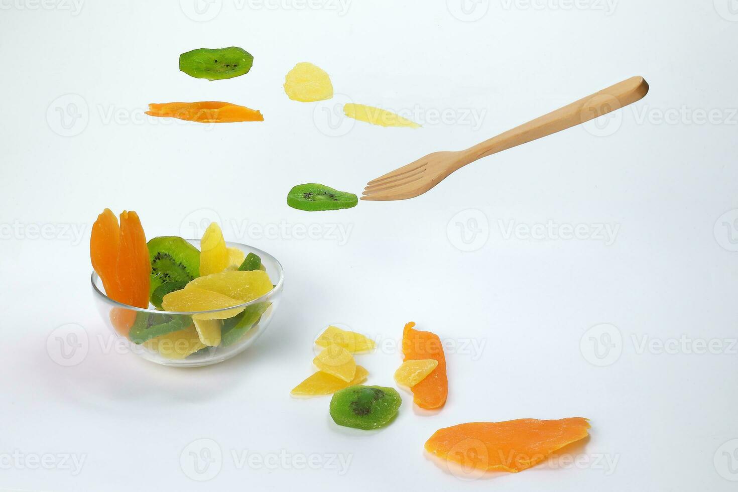 Dry preserved green kiwi pineapple ripe fruit slice colorful sweet on black marble slate background glass bowl flying floating elevated drooping photo