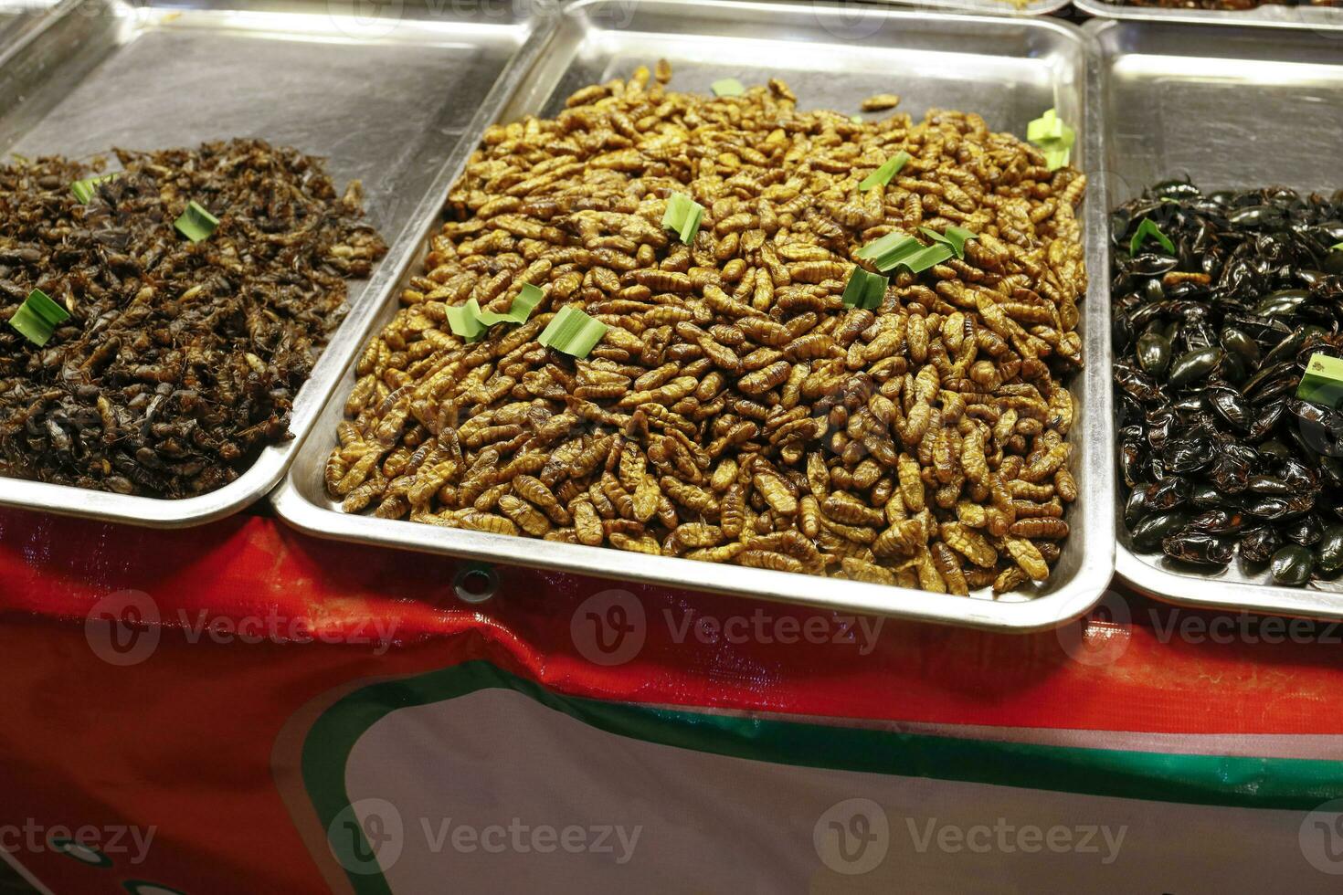 Larvie grasshopper bittles various fried insects sold in Thailand night market photo