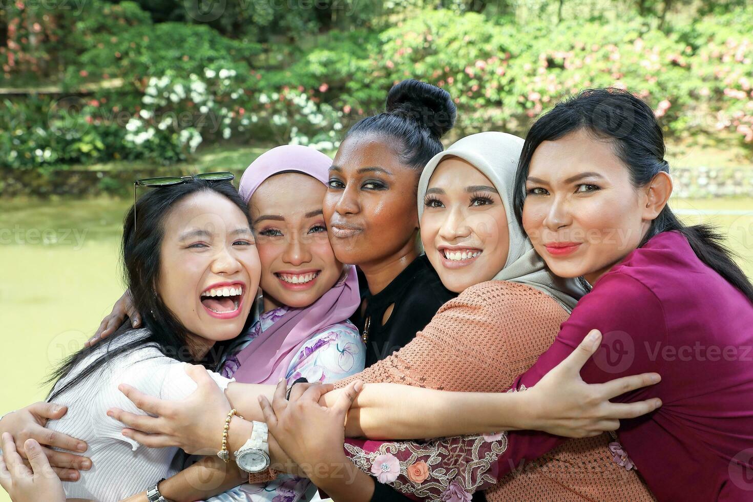 group of five woman friends Malay Chinese Indian Asian outdoor park lake nature hugging caring laughing happy photo