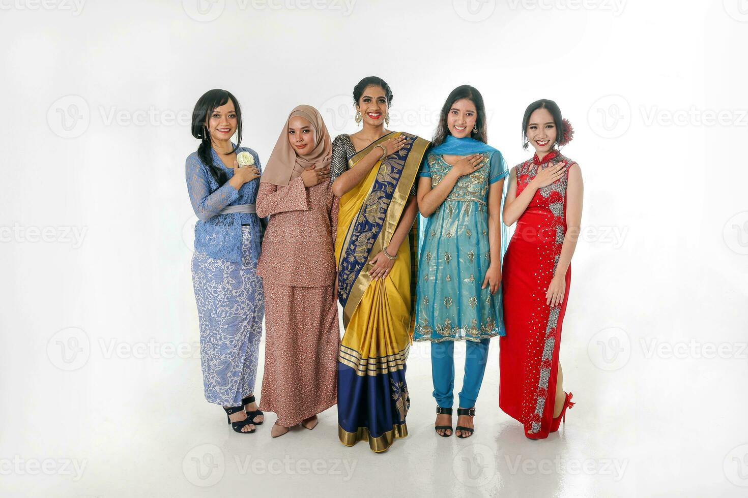 South east Asian Malay Chinese Indian race ethnic origin woman wearing dress costume baju kurung cheongsam samfu kebaya Sharee multiracial community on white background welcome hand on chest photo