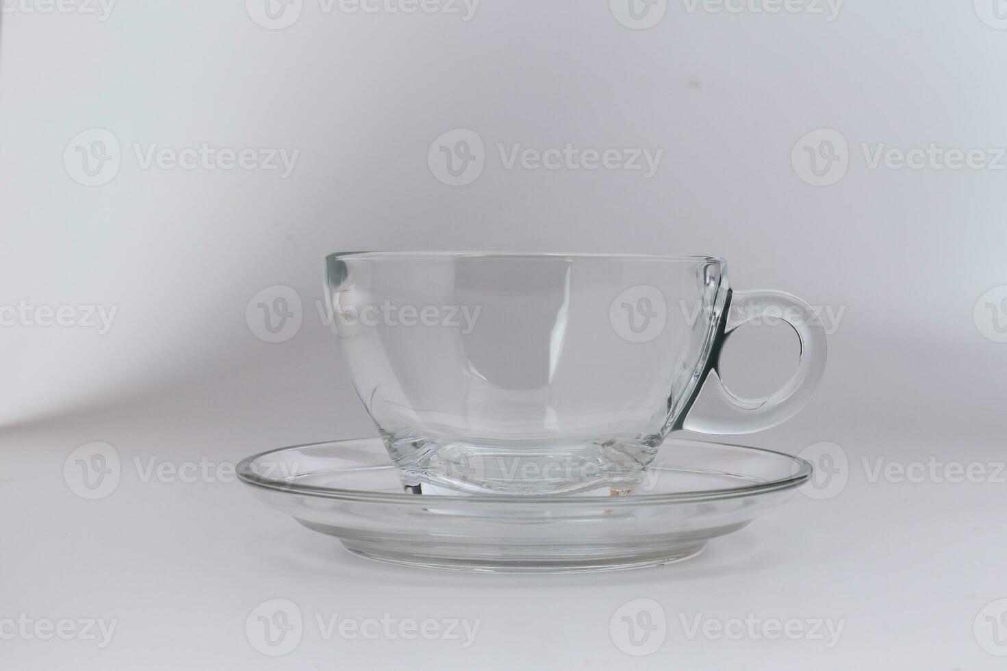 Tetera de cristal transparente con té negro y taza de té vacía