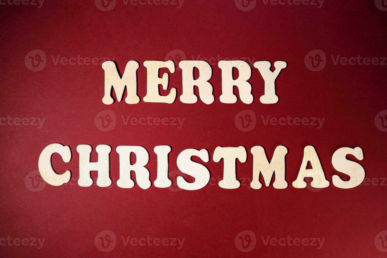 Merry Christmas sign on red paper background color wooden alphabet photo