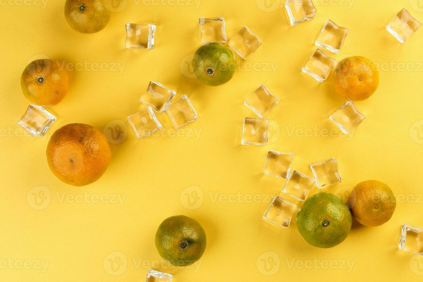 small yellow green mandarin ice cube orange on yellow colour paper background copy space for text photo