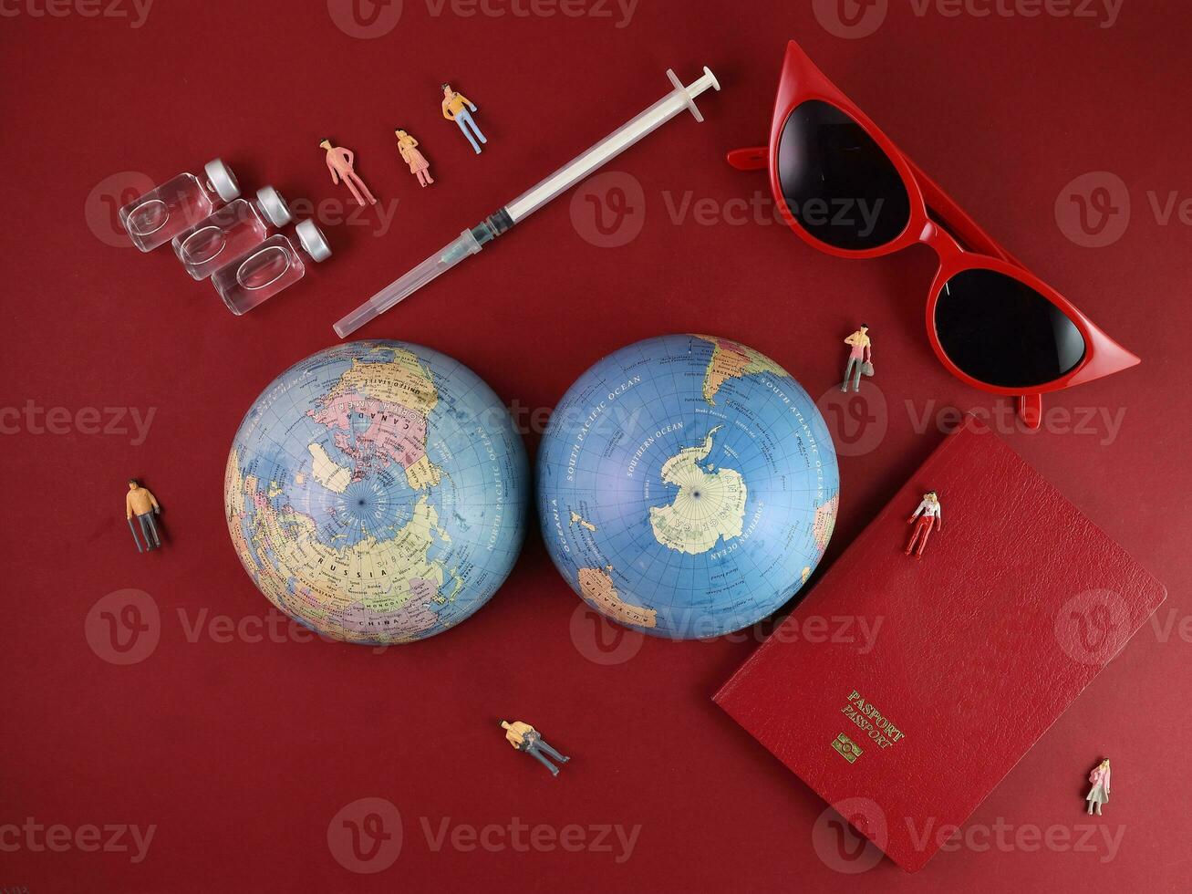 Vaccine passport red sunglass world atlas globe map north south pole on red paper background world travel tour vacation mini human figures medical needle syringe bottle photo