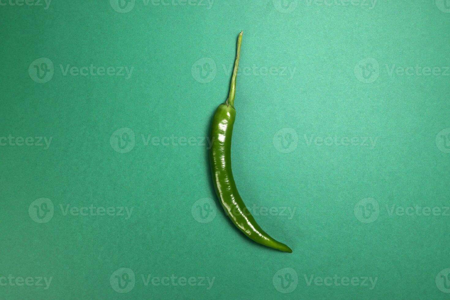 whole green chilli pepper on green background photo