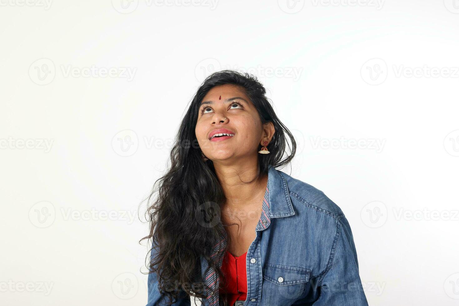 Young attractive Asian Indian woman pose face body expression mode emotion on white background look up imagine think dream photo