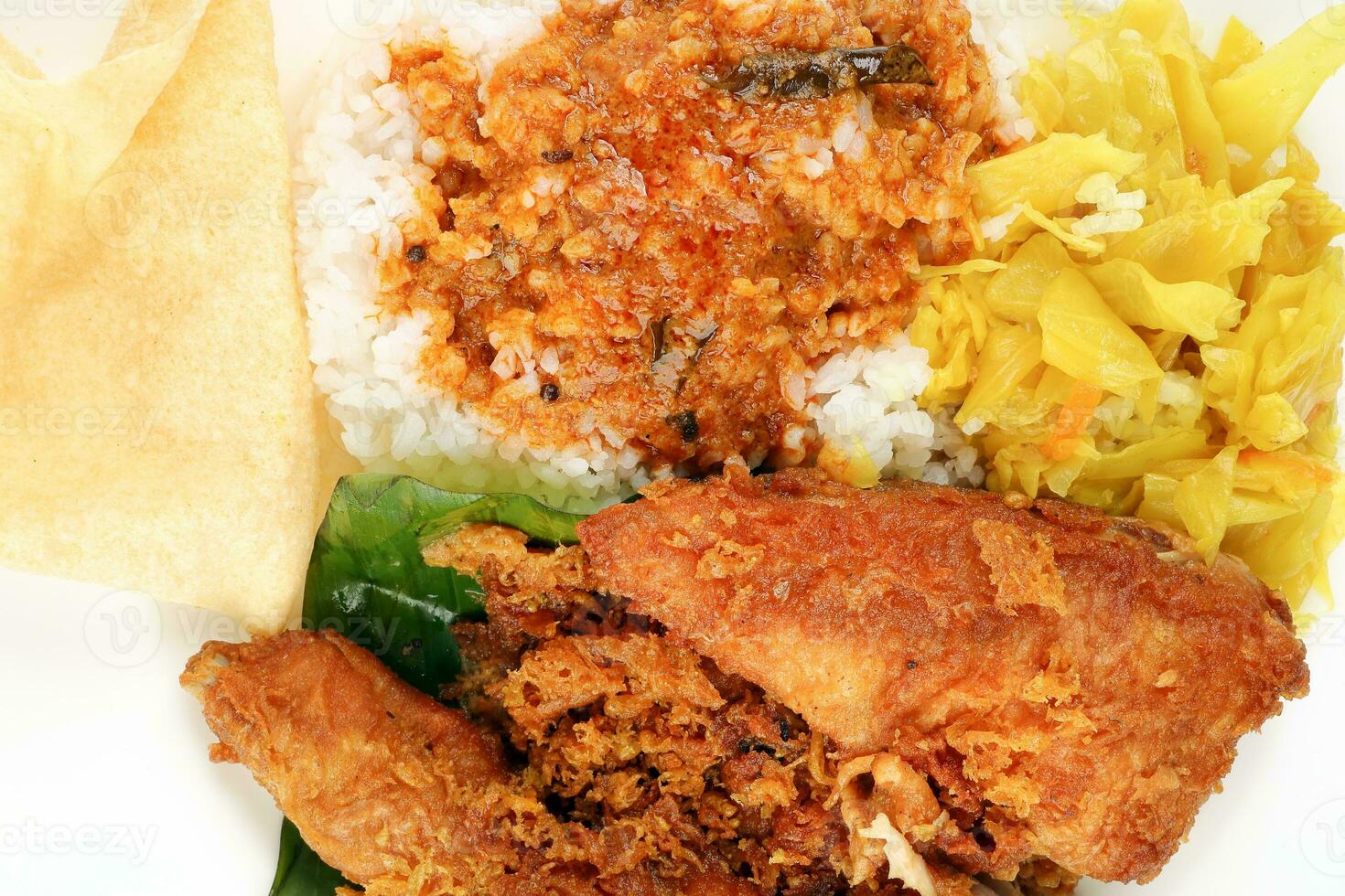 Traditional Malaysian Indian food white rice cabbage vegetable meat deep fried chopped chicken leg topped up with spicy mix gravy white background photo