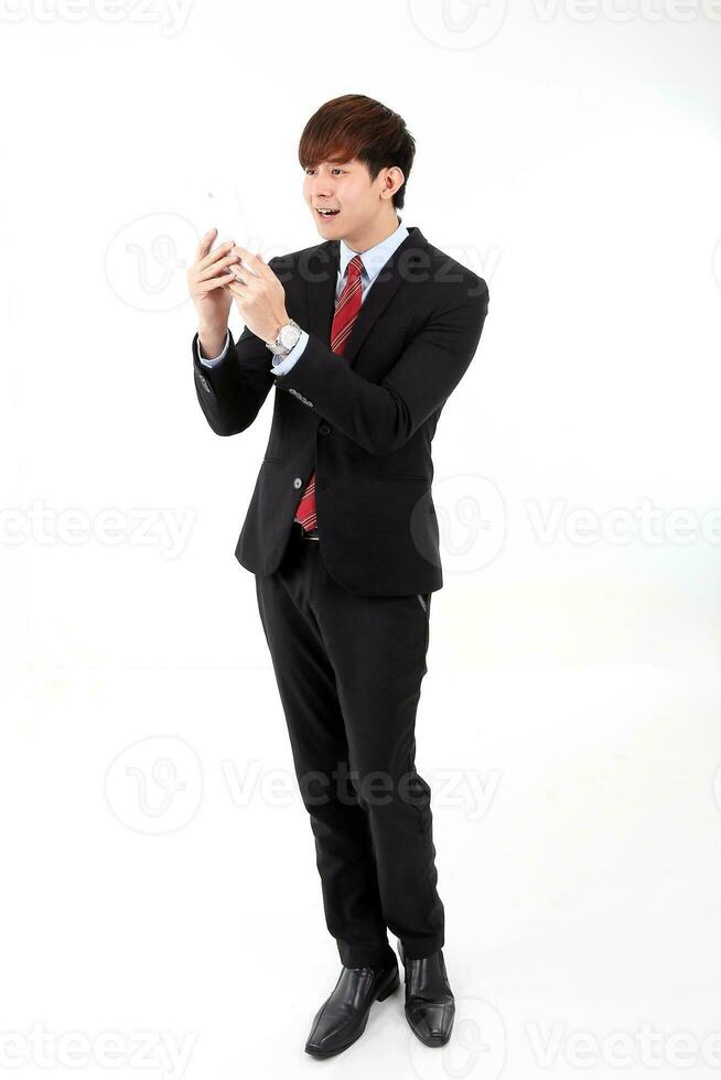 Young smart handsome Asian man business office wearing suit tie on white background looking at smartphone massage worried thinking photo