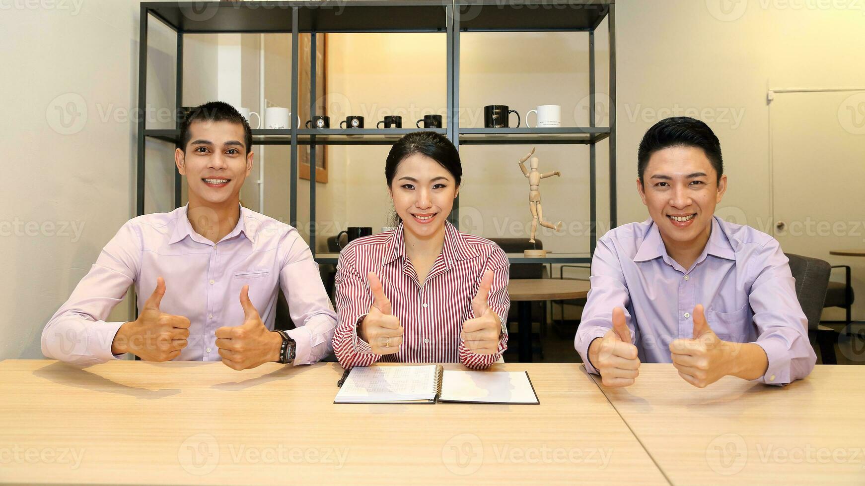 Young south east Asian middle eastern man woman business colleague outdoor cafe chair table meeting talking discussing file paper thumbs up look at camera photo