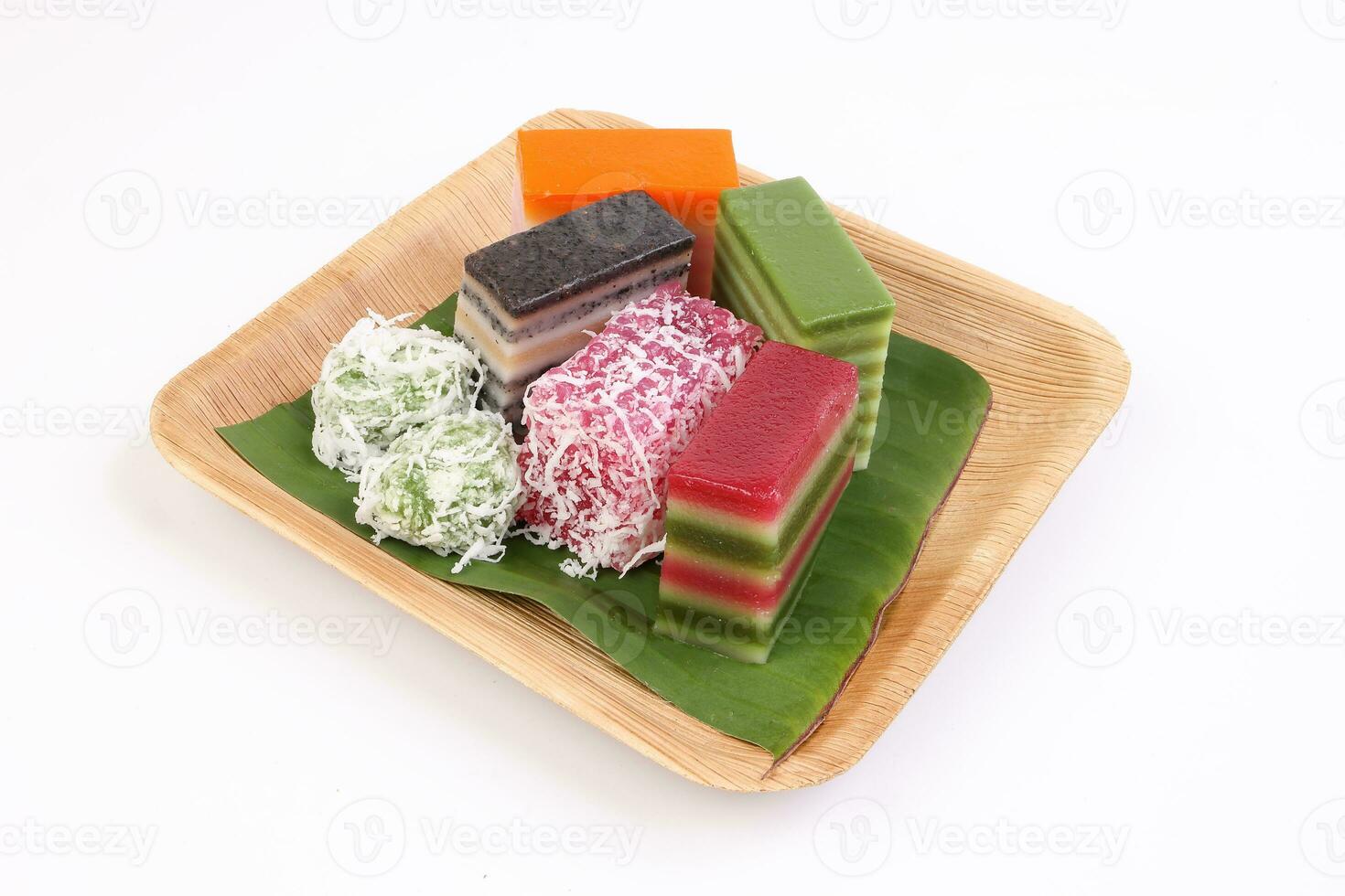 assorted mixed colourful kuih nyonya sweet desert on palm leaf plate on white background photo