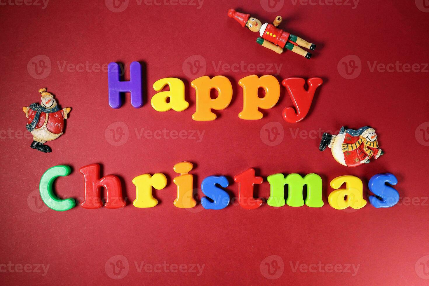 Happy Christmas sign on red paper background color plastic alphabet Santa clause nutcracker ornament photo