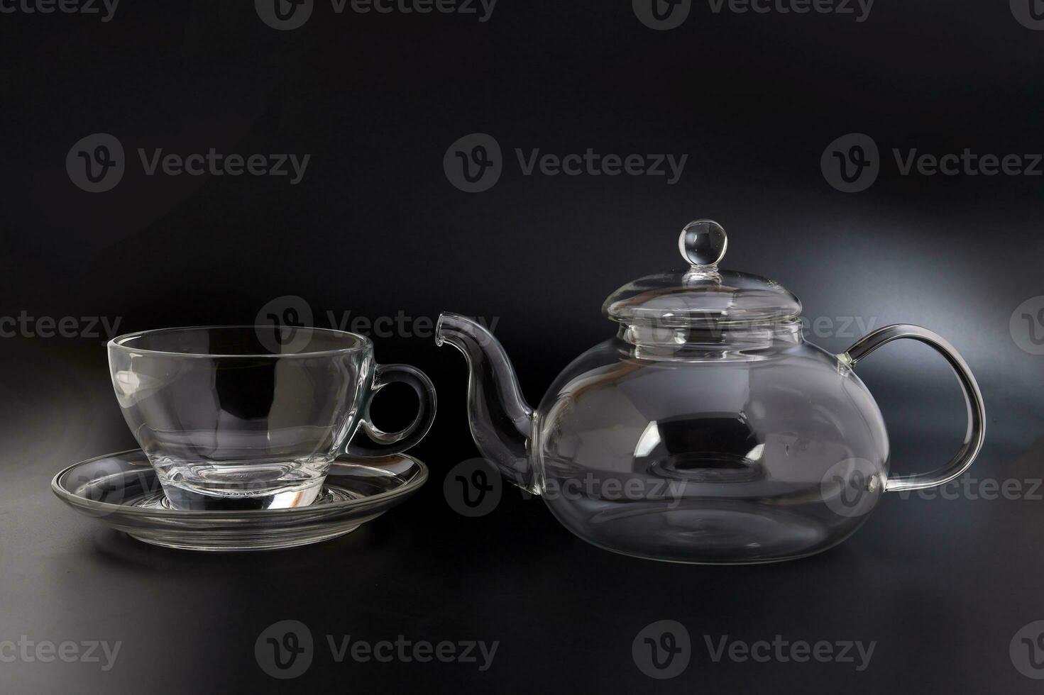 Empty transparent glass see through teapot kettle coffee tea cup saucer set on black background photo