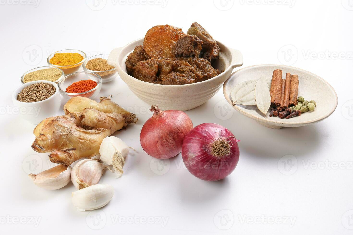 Beef bhuna dry curry with potato in ceramic bowl ingredients chilli cumin coriander turmeric powered salt onion garlic ginger bay leaf cinnamon cardamom clove over white background photo