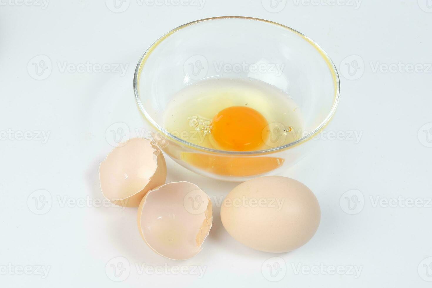 Raw Egg Yolk and white liquid in transparent glass bowl eggshell white
