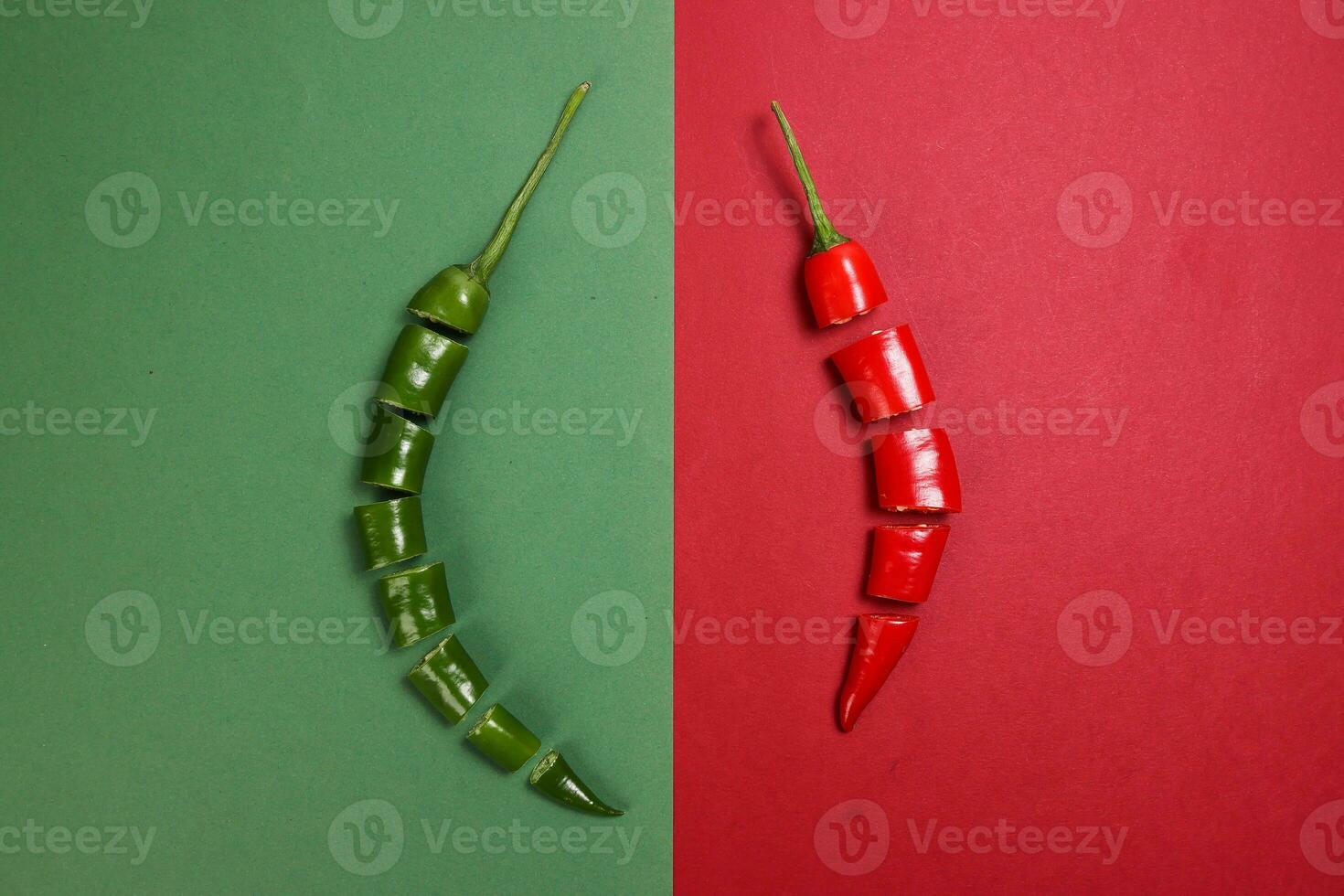 green red chilli pepper on green red paper background cut pieces seeds photo