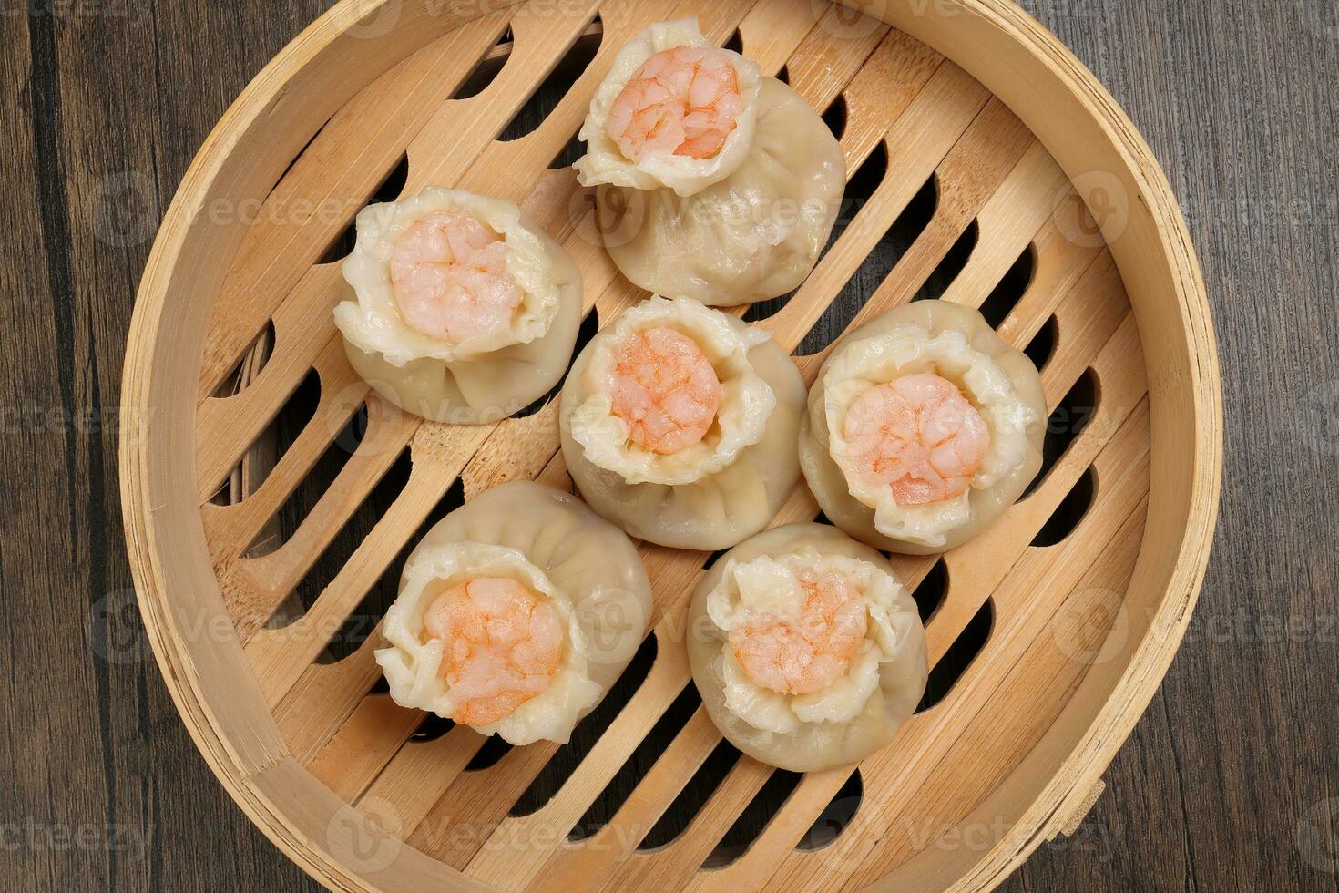 Prawn shrimp shaomai dim sum dumpling in bamboo steamer on rustic wood background photo