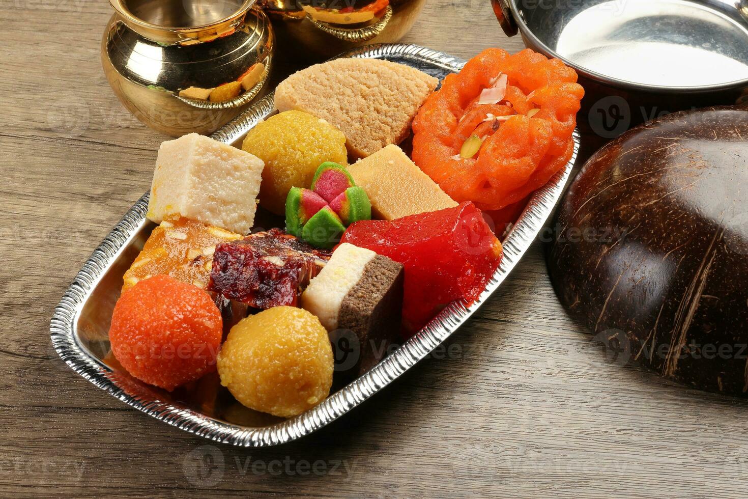 Colourful variety of Indian sweet desert jilepi jilapi amriti halva sondesh barfi laddu on silver tray traditional festival photo