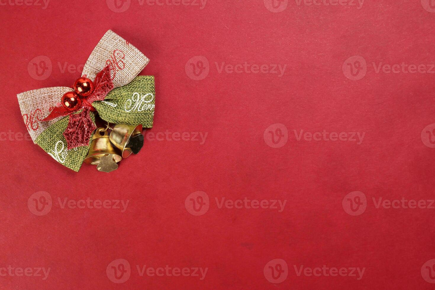 Small Christmas xmas gift bow ribbon Pine Arrangement bell on red background copy text space photo