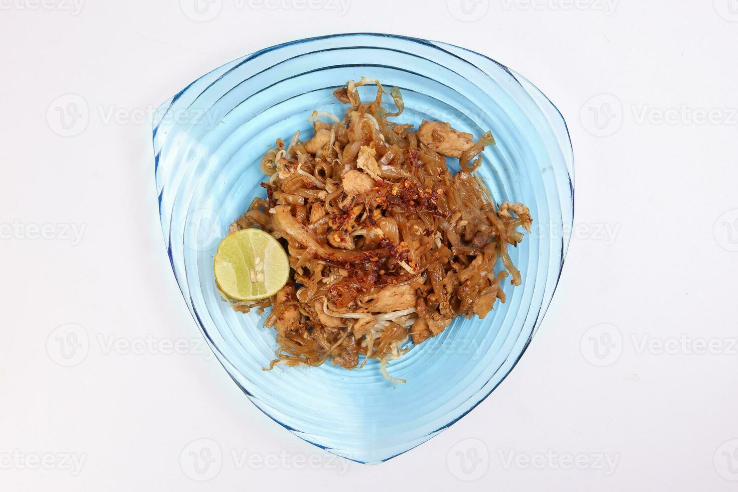 Thai style stair fried flat rice noodles pad thai on a blue glass triangular plate on white background photo