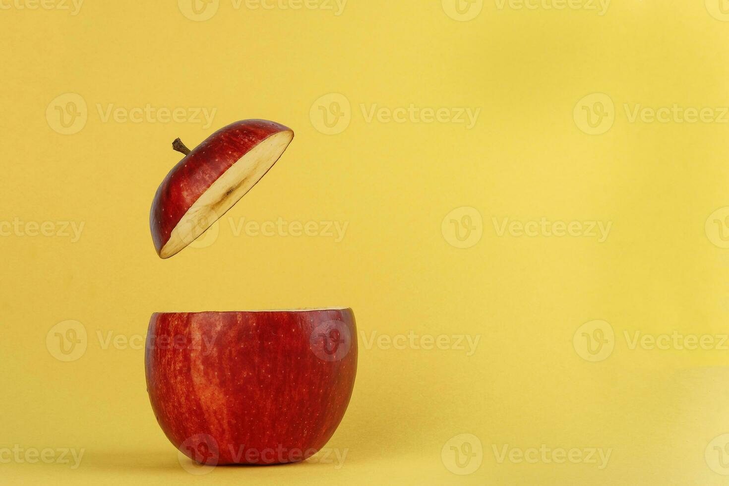 Healthy Red Cut Apple floating top slice juice drink idea concept on yellow background photo