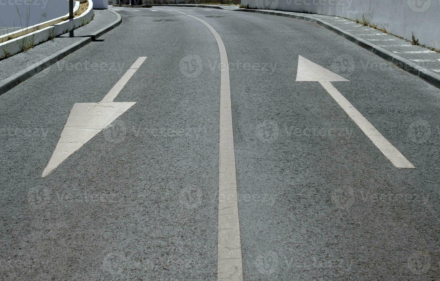 Road with two arrows pointing into opposite directions photo