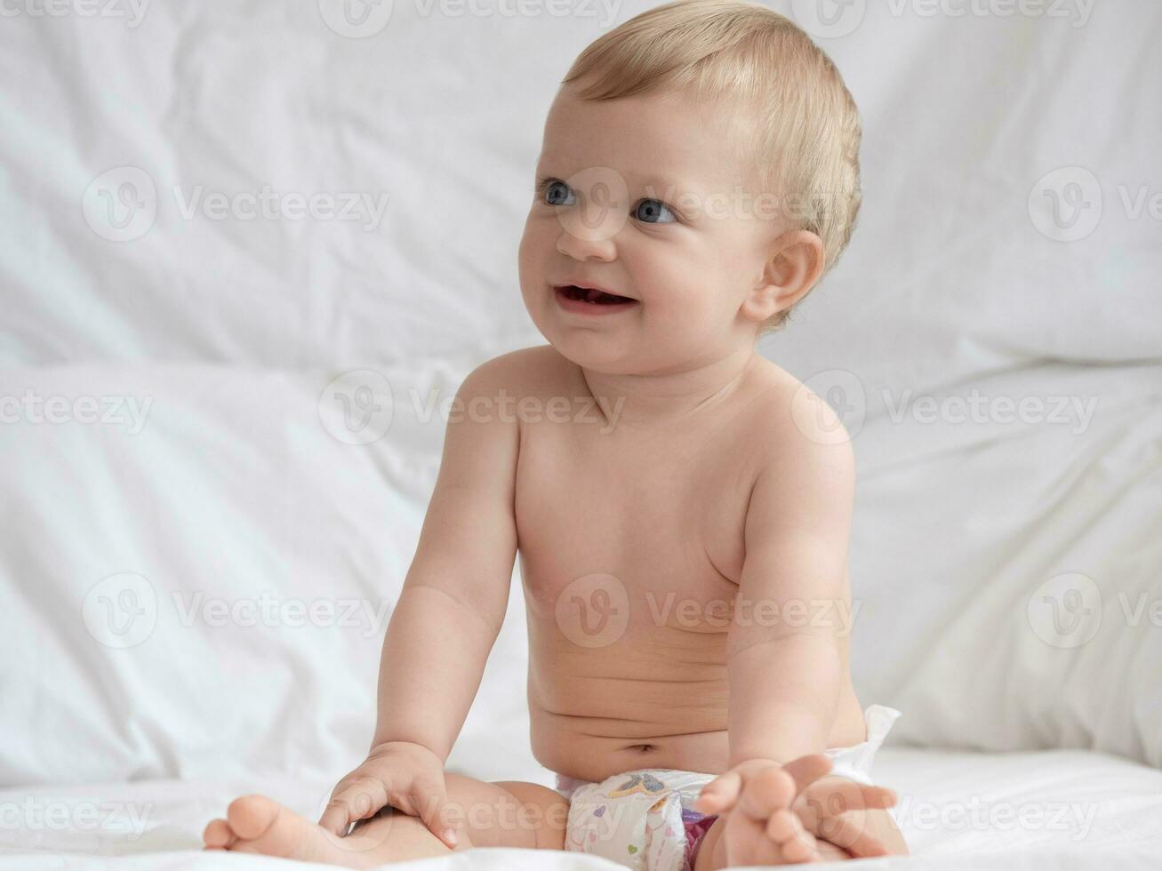 Cute Baby Sitting and Smiling on The Bed photo