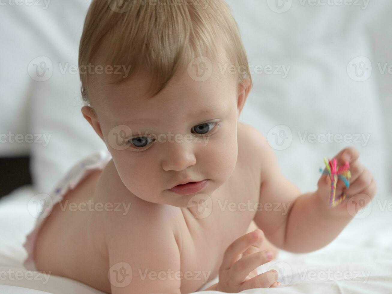 Blond blue eyes baby on the bed photo