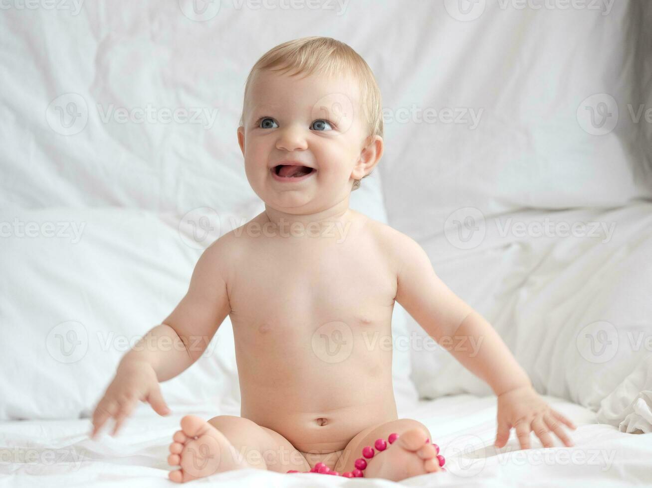 Baby on Bed Playing With Beads photo