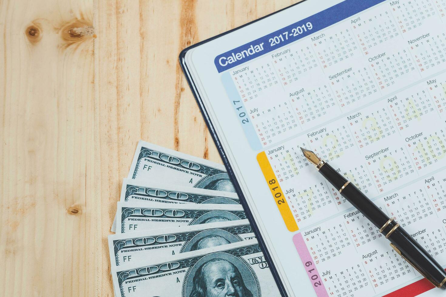 Calendar planner with fountain pen and hot coffee on wood table.office tool. photo