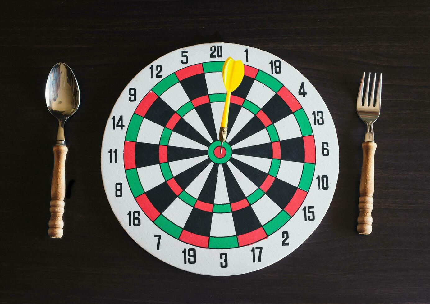 Dart board with spoon and folk on backround. photo