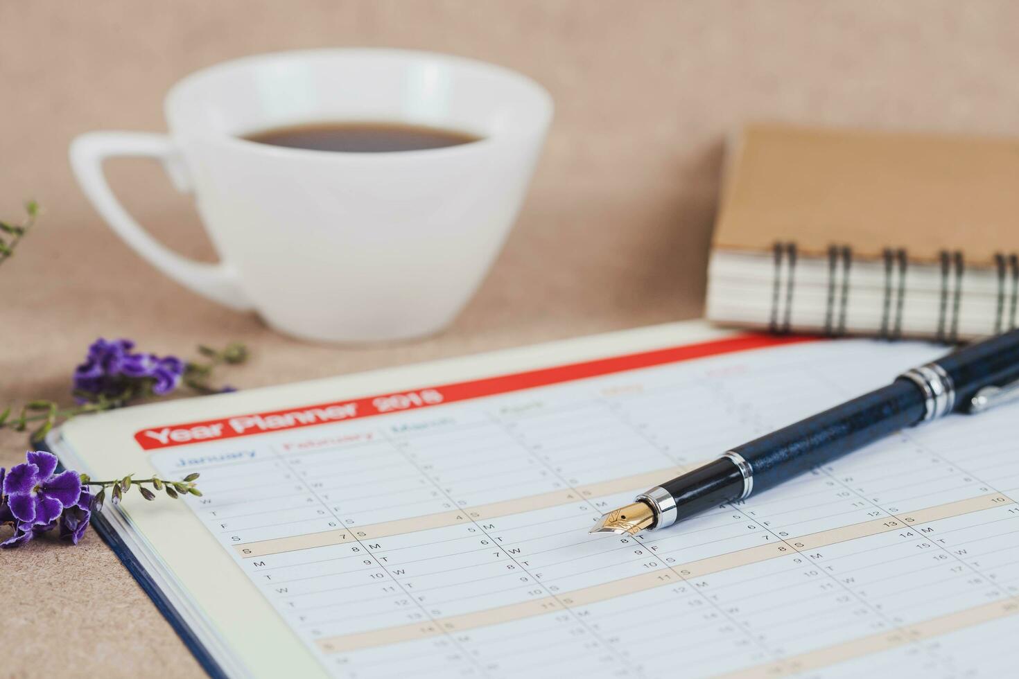 personal organizador o planificador con fuente bolígrafo y caliente café en madera mesa. foto