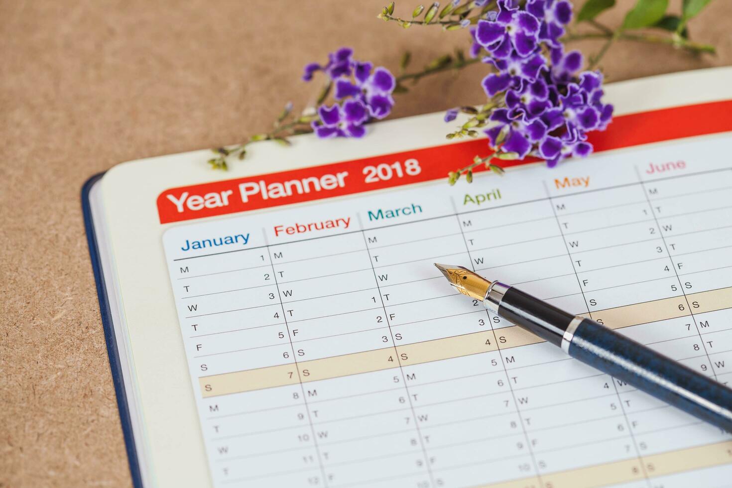 personal organizer or planner with fountain pen on wood table. photo