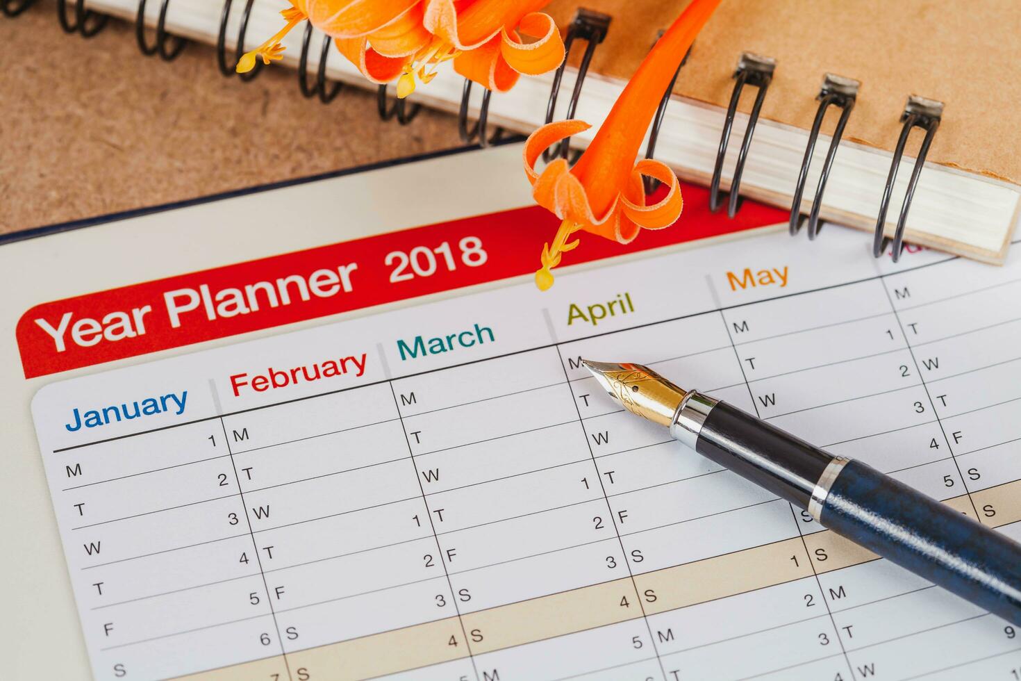 personal organizer or planner with fountain pen on wood table. photo