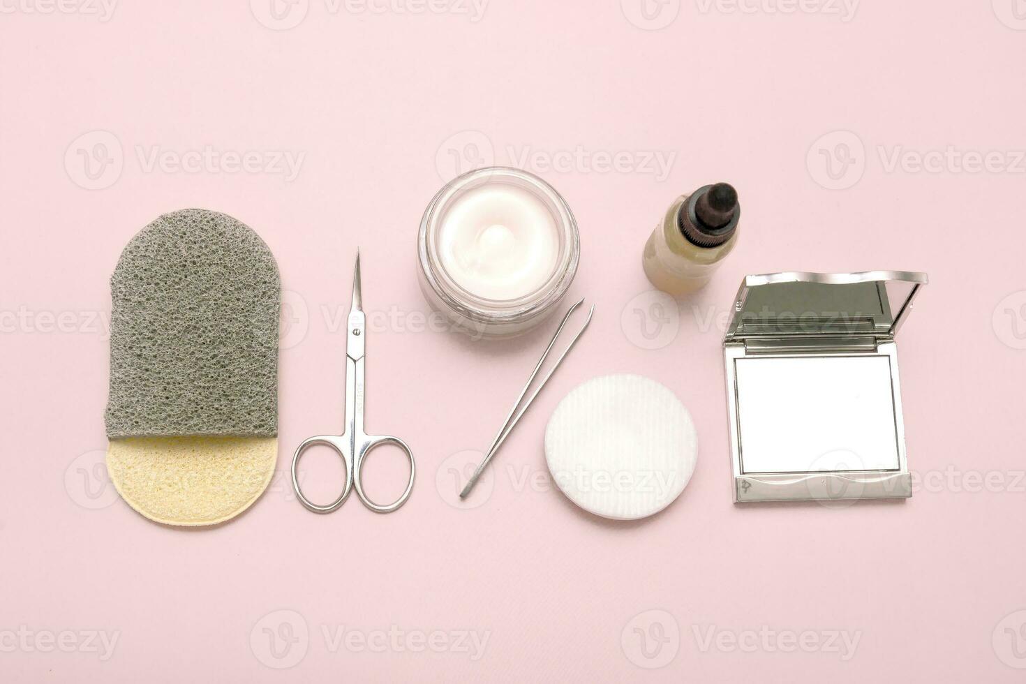 set of personal care accessories, a mirror, a facial sponge, serum, scissors, tweezers, cotton pads, a jar of cream photo