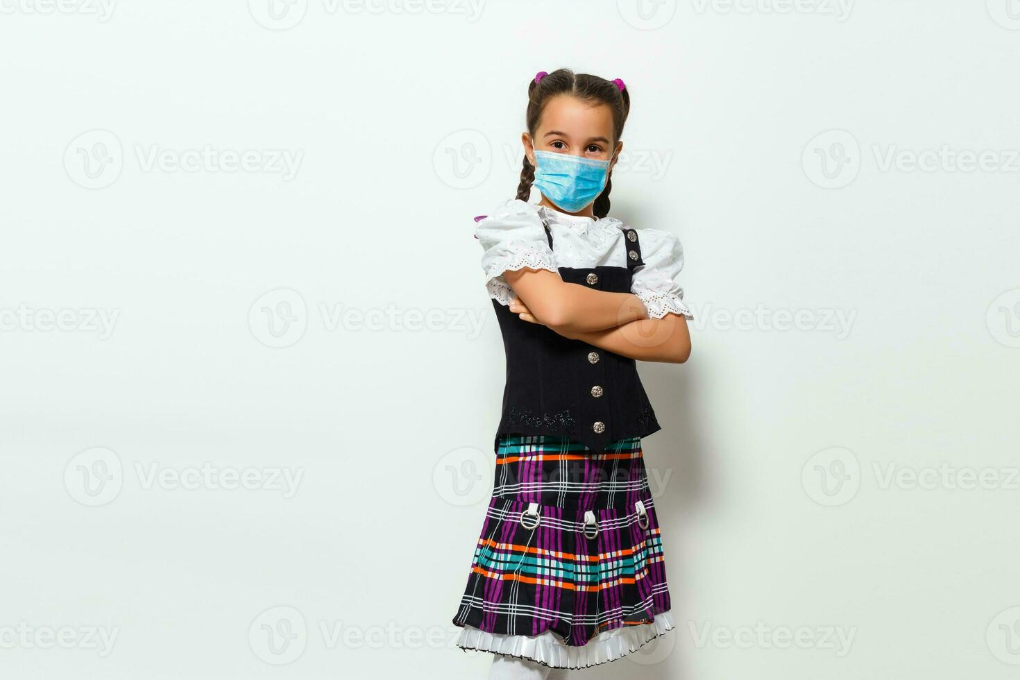 Masked child - protection against influenza virus. Little Caucasian girl wearing mask for protect pm2.5. baby on a gray background with copy space. epidemic, pandemic. photo