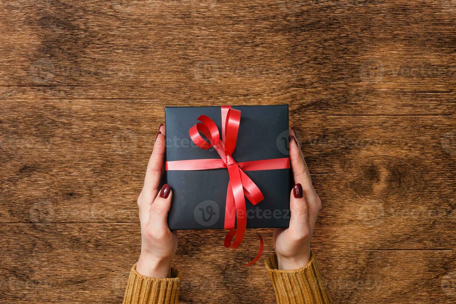 Man holding Christmas presents laid on a wooden table background photo