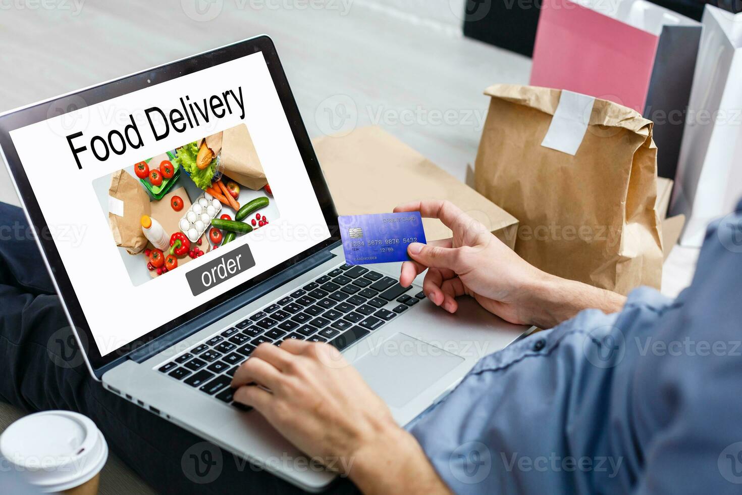 Man ordering take away food by internet with a laptop while lying at home. photo