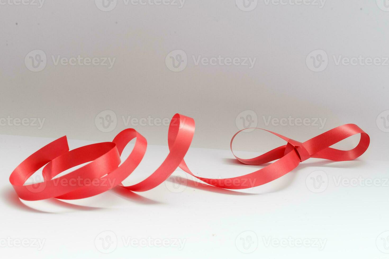 Shiny red satin ribbon on white background photo