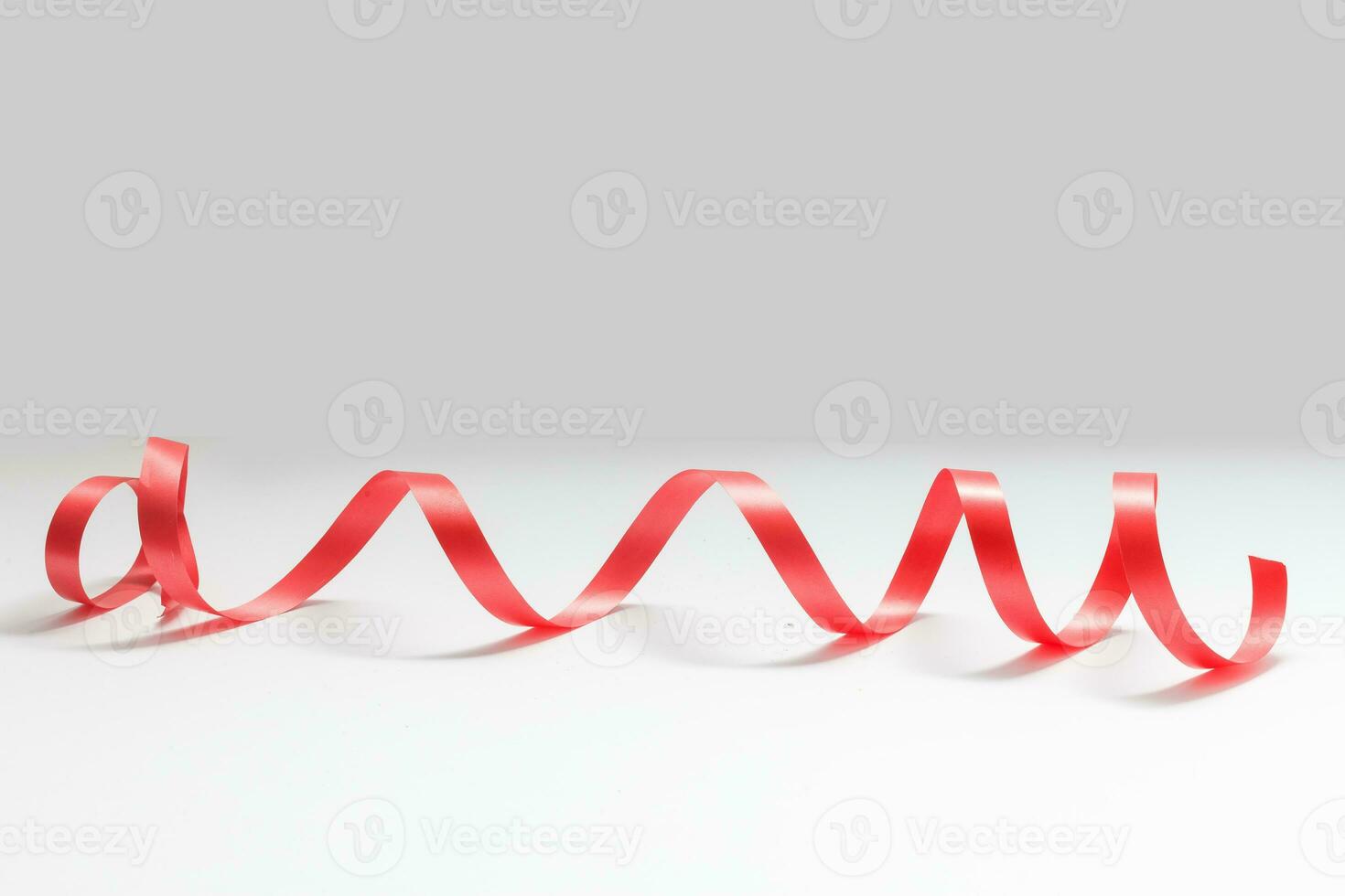 Shiny red satin ribbon on white background photo