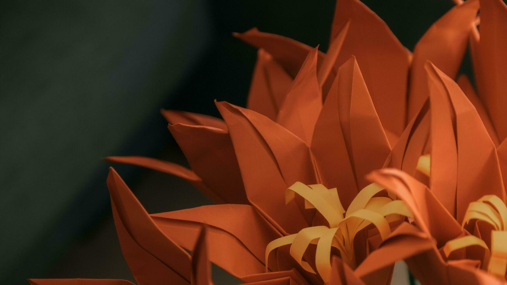 un cerca arriba de un origami flor con naranja hojas foto