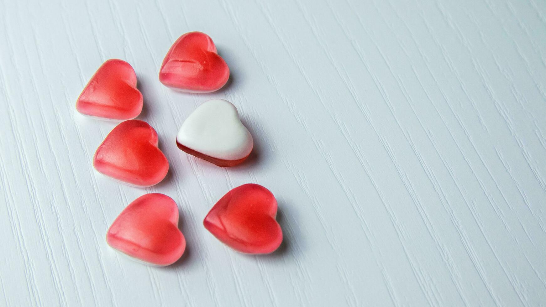Heart shaped gummies on white background photo