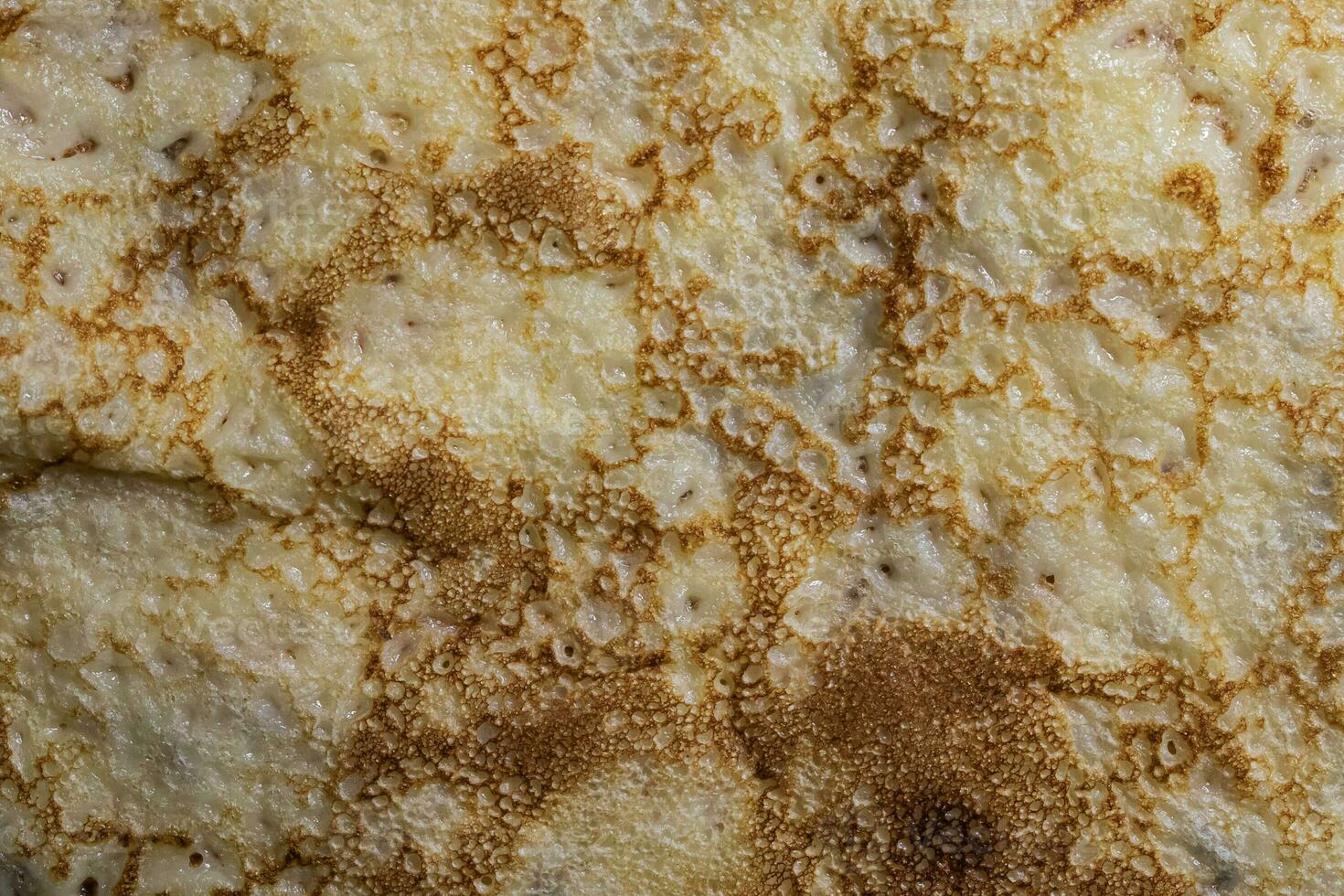 Pancake surface texture and pattern. Close-up of thin hot pancakes in a plate. Traditional rustic food. Graphic resource. photo