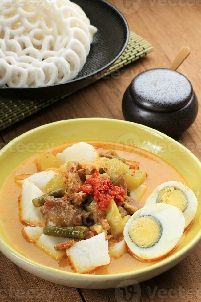 Close Up Lontong Sayur Padang with Boiled Egg and Crackers photo